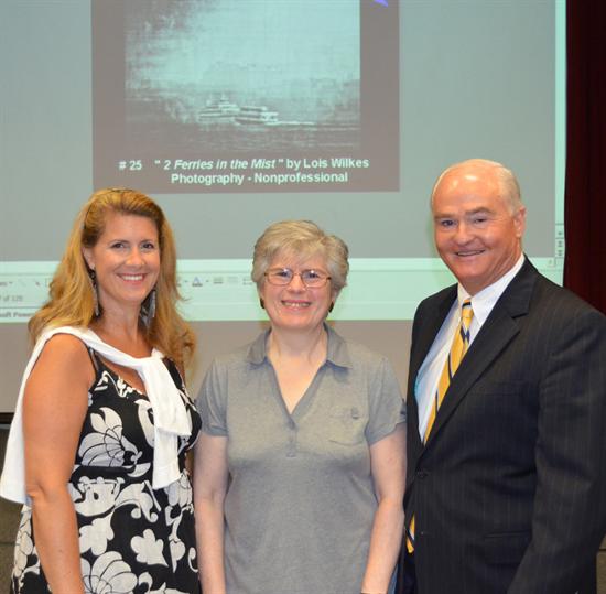Best in Show (non-professional category) winner Lois Wilkes of Middletown is congratulated by Monmouth County Freeholder Director John P. Curley (left) and Freeholder Serena DiMaso (right) for her photograph entitled “Ferries in the Mist.”